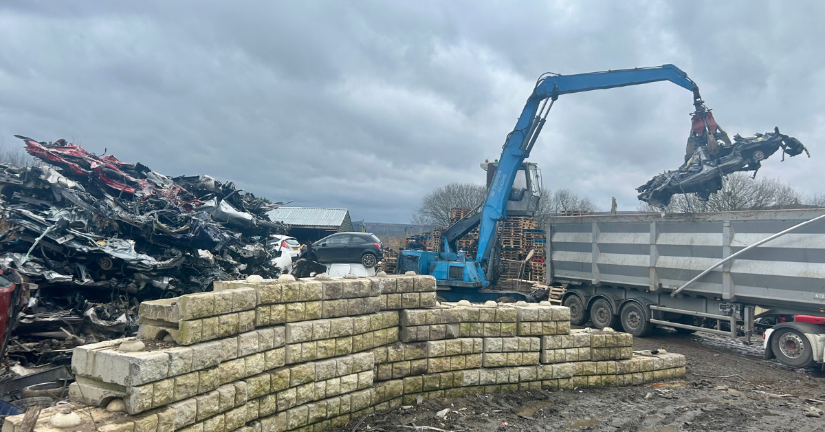 Fuchs grab at Scrap Local loading scrap cars into a bulker for recycling