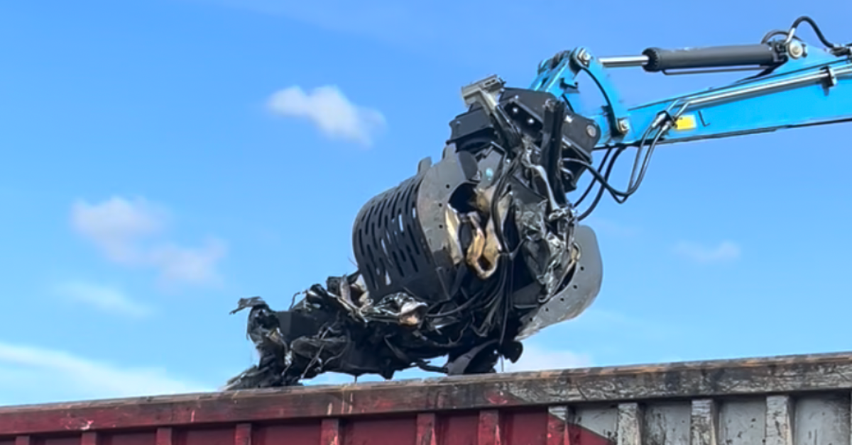 Fuchs grab at Scrap Local loading metal waste for recycling.