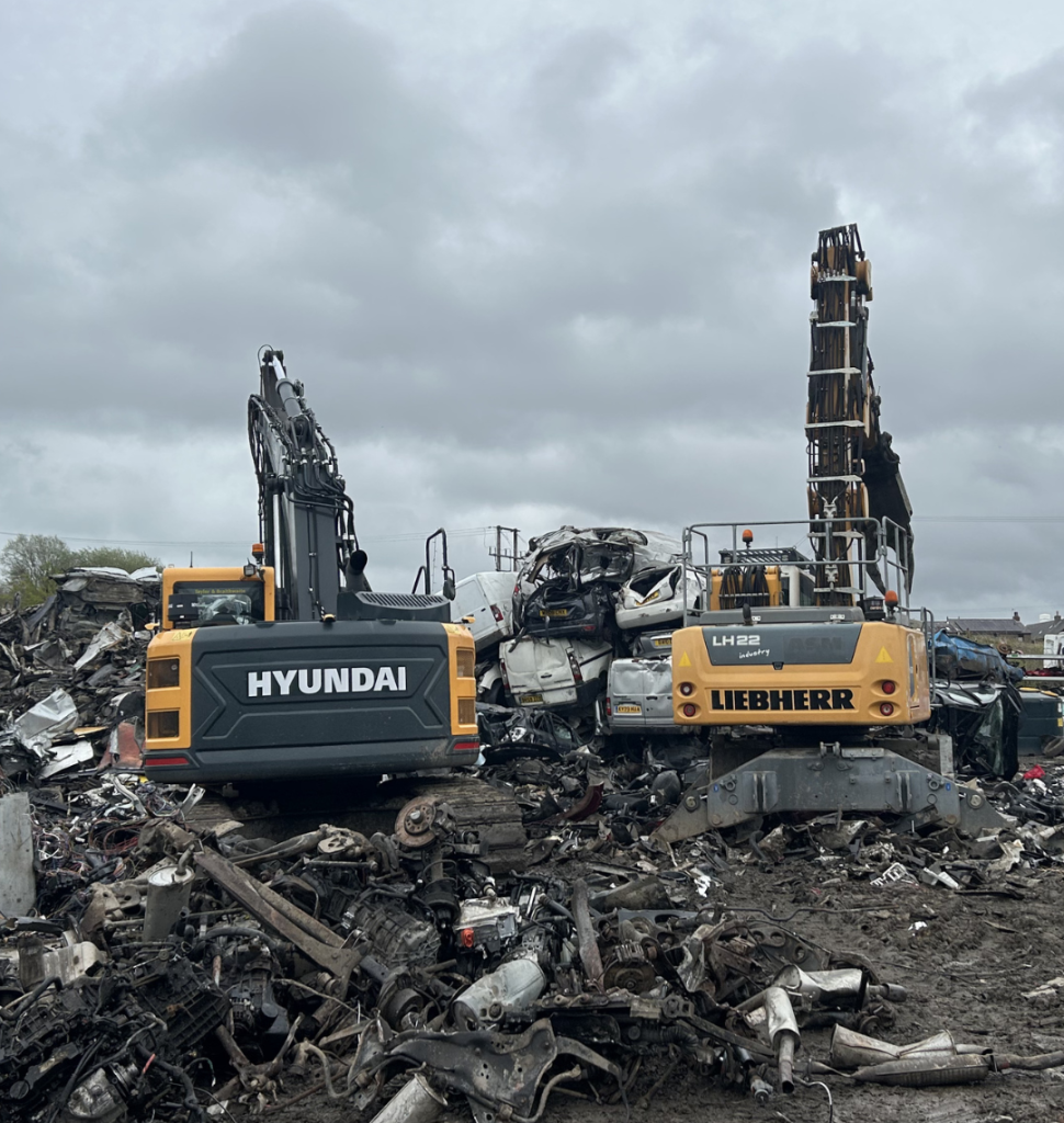 Excavators crushing scrap cars in scrapyard