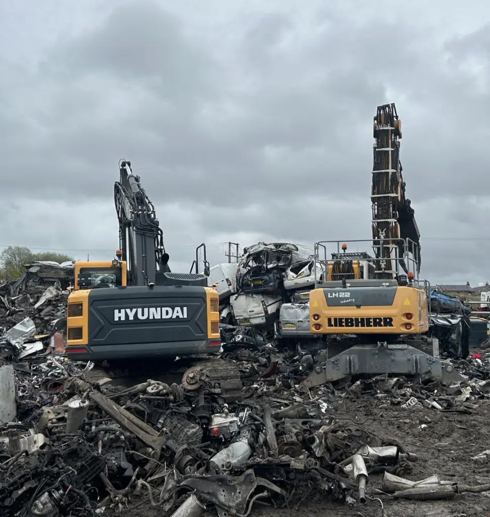 Excavators crushing scrap cars in scrapyard