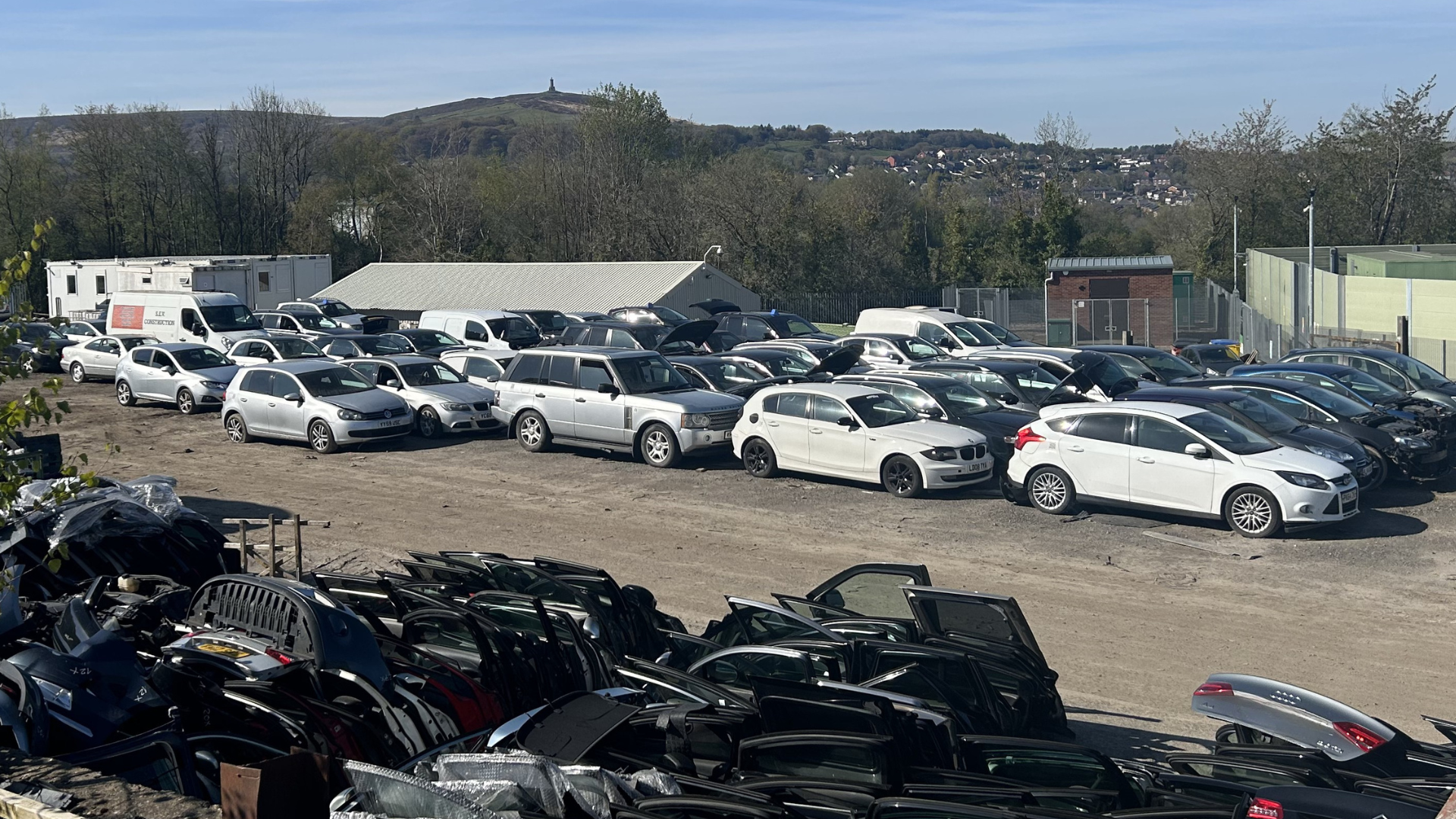 Car scrapyard with rows of damaged vehicles