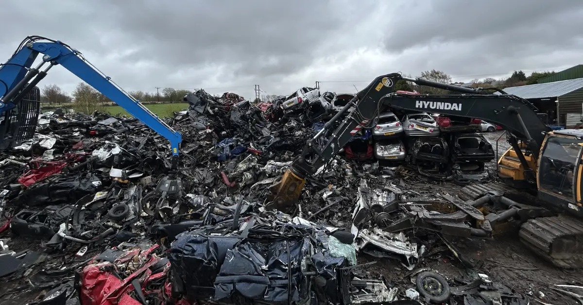 Excavators sorting crushed cars in scrapyard